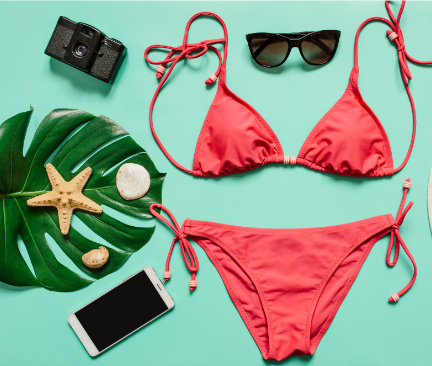Rød trekantsformet bikini, solbriller og kamera